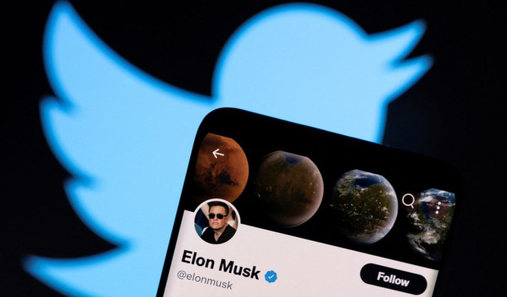 Elon Musk's twitter account is seen on a smartphone in front of the Twitter logo in this photo illustration taken, April 15, 2022. 