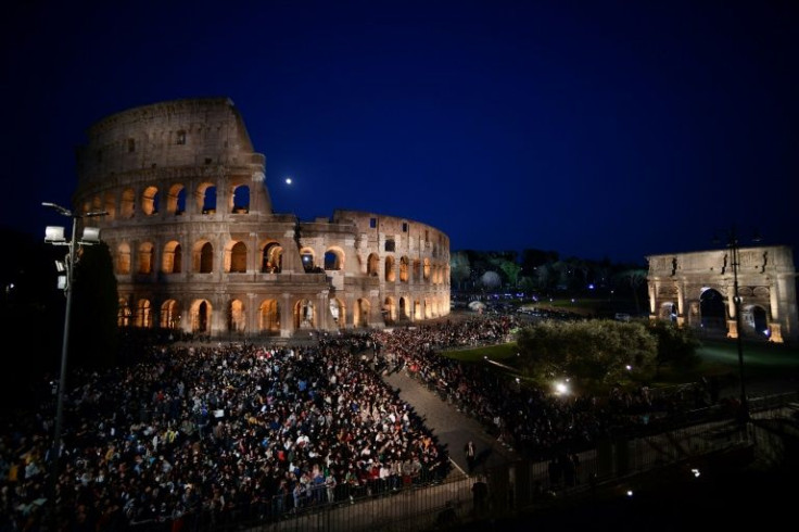 Christian worshippers gather by the Colosseum to attend the Way of The Cross in Rome on Friday