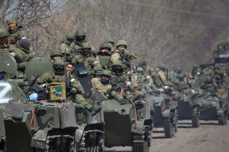 Service members of pro-Russian troops ride on armoured vehicles in the course of Ukraine-Russia conflict on a road leading to the city of Mariupol, Ukraine April 15, 2022.  