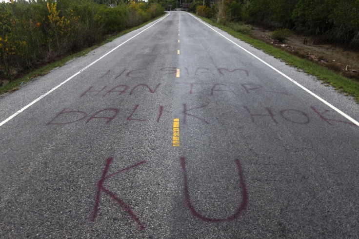 Separatist graffiti is seen on a road near Pattani June 6, 2014, one of three southernmost provinces of Thailand where government troops have fought Muslim insurgents since 2004. Graffiti reads "Hey Siamese - bring back our rights"
