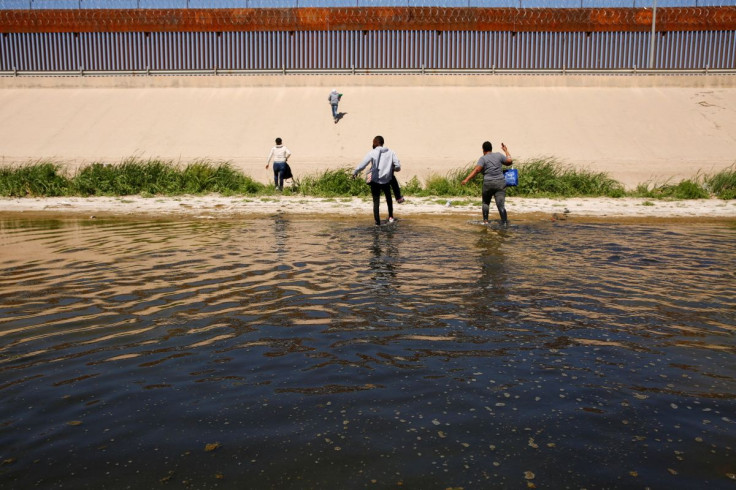 FILE PHOTO - Asylum-seeking migrants walk out of the Rio Bravo river after crossing it to turn themselves in to U.S Border Patrol agents to request asylum in El Paso, Texas, U.S., as seen from Ciudad Juarez, Mexico April 13, 2022. 