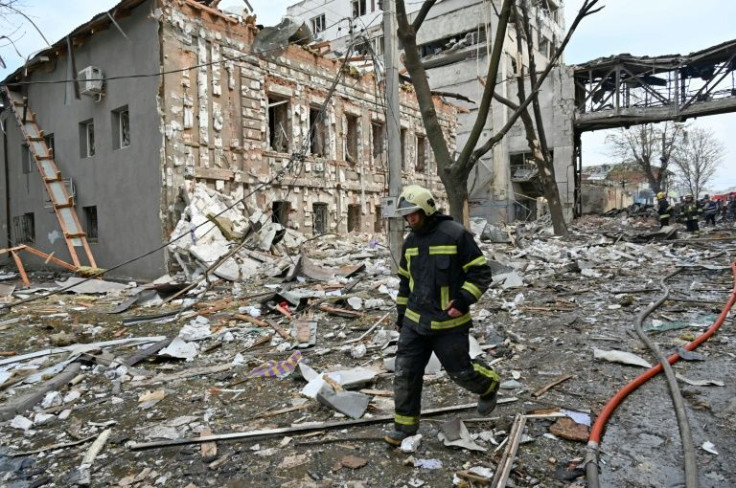 The smell of bread blends with the acrid odour of burnt out cars. A walkway spanning the road is crumpled like an accordion. To the side, the balconies of an apartment block have been dismantled by the shockwave