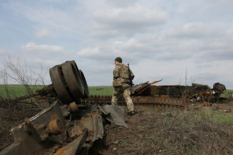 A Ukrainian serviceman walks past a destroyed Russian tank near the village of Gusarovka in the Kharkiv region of eastern Ukraine on April 16, 2022