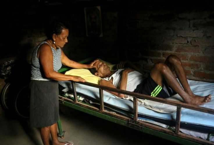Justo Rodriguez is helped by his sister Esmerita at his house on Nicaragua's Ometepe island on April 14, 2022