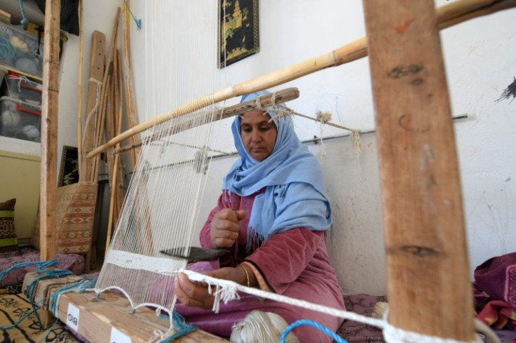 A Tunisian craftswoman weaves a rug at a workshop run by Shanti, a social enterprise that helps artisans from across the North African country