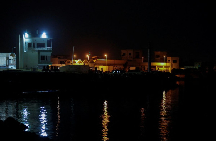 People stand at the port of Gabes, after a merchant fuel ship sank off its coast the previous day, Tunisia April 16, 2022.