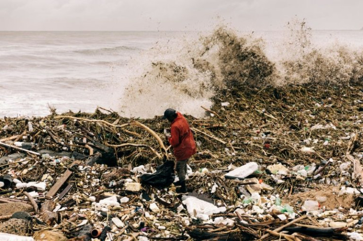 A man tries to collect plastic bottles amid debris at the Blue Lagoon beach after days of flooding in the coastal city of Durban which has left almost 400 people dead and tens of thousands homeless