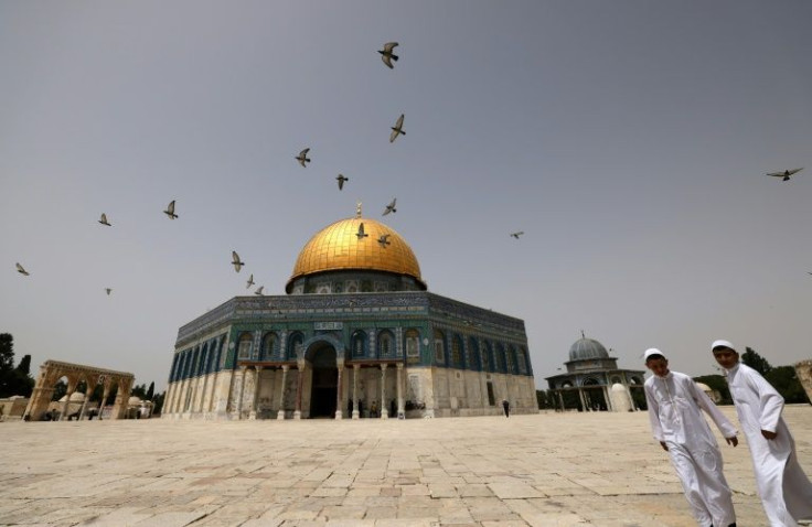 Palestinian Muslims walk in front of the Dome of Rock at the Al-Aqsa mosque compound on Sunday