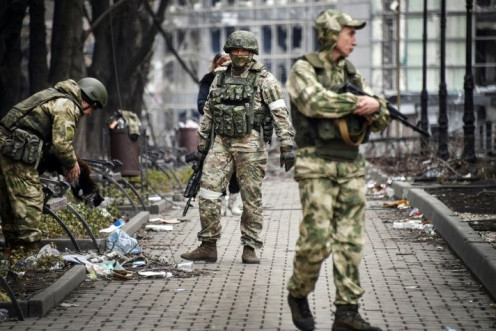Russian soldiers patrol a street in Mariupol on April 12, 2022, as Moscow intensifies a campaign to take the strategic Ukrainian port city