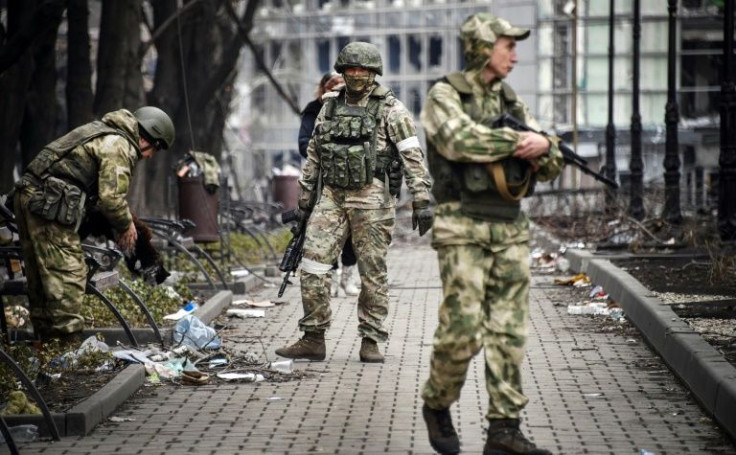 Russian soldiers patrol a street in Mariupol on April 12, 2022, as Moscow intensifies a campaign to take the strategic Ukrainian port city