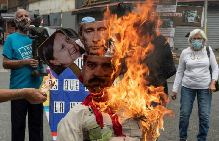 Opponents of Venezuela's government burn an effigy bearing the images of President Nicolas Maduro and Russian leader Vladimir Putin as part of Easter celebrations