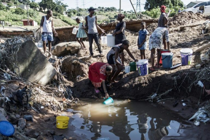 Residents in Durban's Inanda district collect water from a pool created by a collapsed road