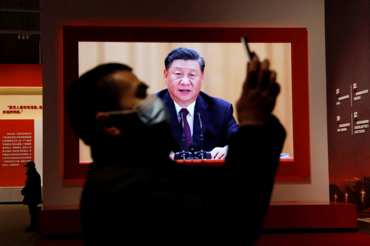 A visitor holds his mobile phone near a screen showing Chinese President Xi Jinping during an exhibition on the fight against the coronavirus disease (COVID-19) outbreak, at Wuhan Parlor Convention Center that previously served as a makeshift hospital for