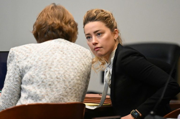 US actress Amber Heard speaks to her attorney at the Fairfax County Circuit Courthouse in Fairfax, Virginia