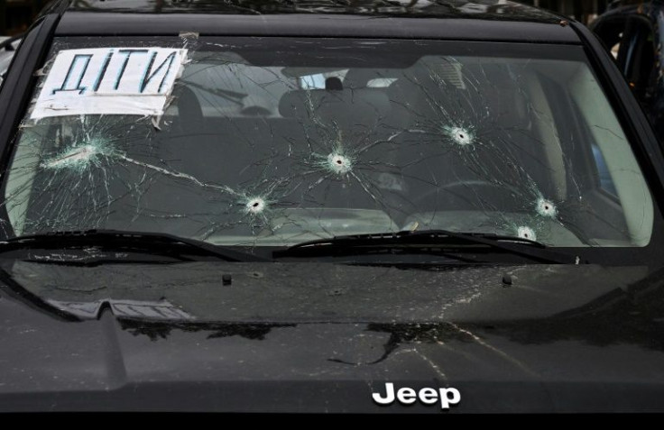 A sign reading 'Children' is seen on the windscreen of a car with bullet holes in Irpin, Ukraine
