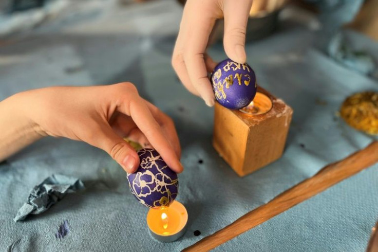Displaced women and children decorated boiled eggs, and iced traditional Easter breads in yellow and blue for the troops