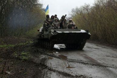 Ukrainian soldiers stand on an armoured personnel carrier, not far from the frontline with Russian troops, in Izyum district, Kharkiv region on April 18, 2022