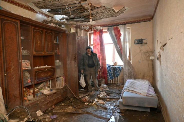 A man looks at his destroyed apartment in a residential building outskirts of Kharkiv
