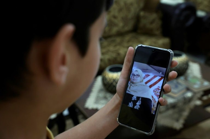 Omar displays a picture of his mother on a phone