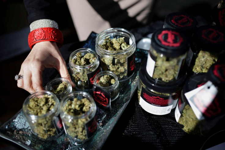 An employee puts down an eighth of marijuana after letting a customer smell it outside the Magnolia cannabis lounge in Oakland, California, U.S. April 20, 2018. 