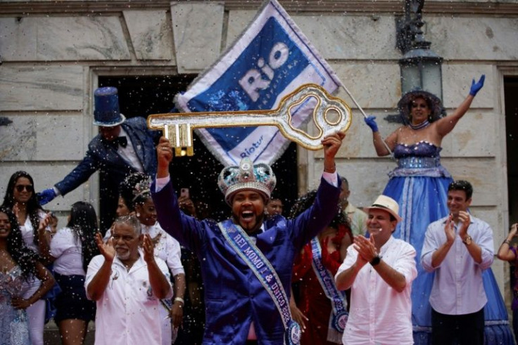 Carnival's symbolic 'King Momo,' Wilson Dias da Costa Neto, holds aloft the keys to the city of Rio de Janeiro during a ceremony that officially kicks off carnival in the Brazilian metropolis after a two-year freeze due to the coronavirus pandemic