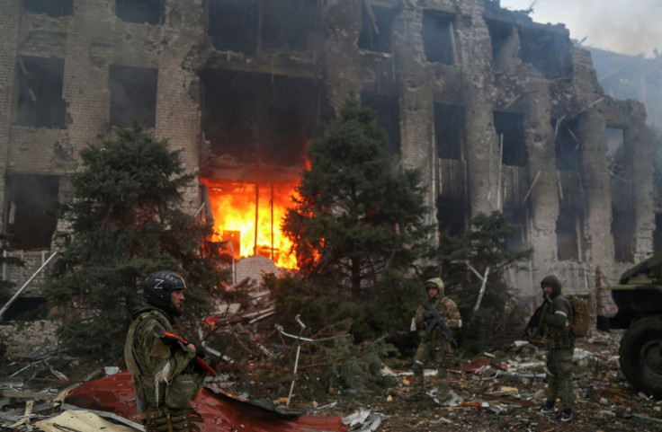 Service members of pro-Russian troops, including fighters of the Chechen special forces unit, stand in front of the destroyed administration building of Azovstal Iron and Steel Works during Ukraine-Russia conflict in the southern port city of Mariupol, Uk