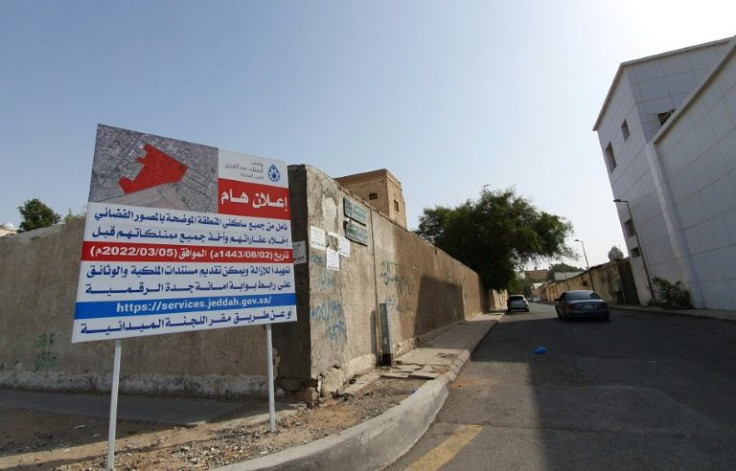 A sign warns people to leave their homes with their belongings before demolition begins