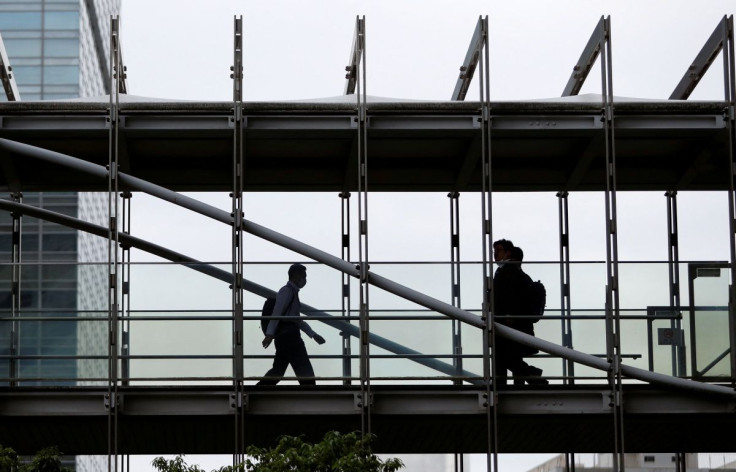 Businessmen wearing protective face masks walk on a pedestrian bridge, amid the spread of the coronavirus disease (COVID-19), in a business district in Tokyo, Japan June 24, 2020. 