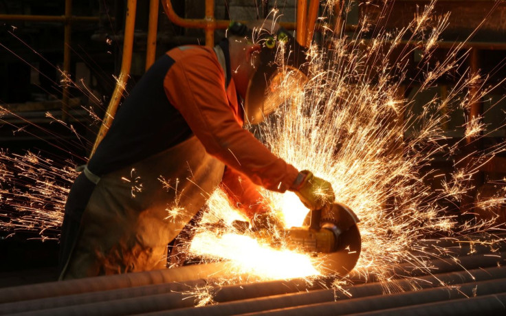 A worker cuts newly manufactured bars of steel at the United Cast Bar Group's foundry in Chesterfield, Britain, April 12, 2022.  