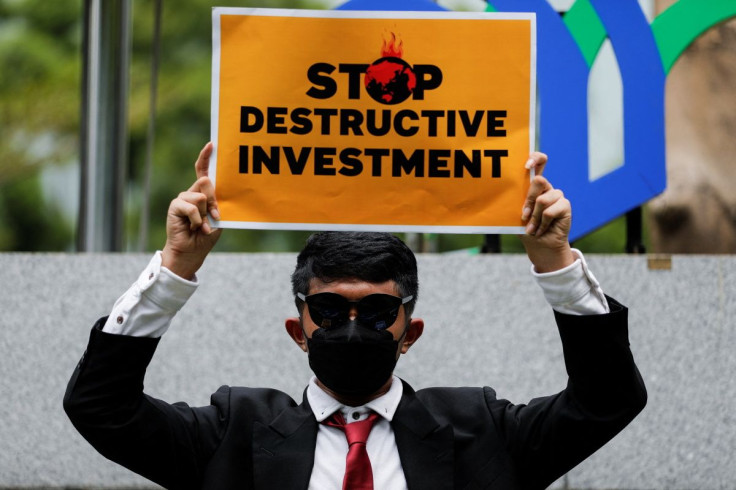 An activist holds a placard while taking part in a rally called "Investment for the Earth, not Oligarchy," asking the government to choose sustainable investment outside the Ministry of Investment's office to mark Earth Day, in Jakarta, Indonesia, April 2