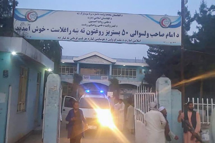 Taliban fighters and medical staff stand outside a hospital gate after an explosion in the Imam Sahib district, north of Kunduz city