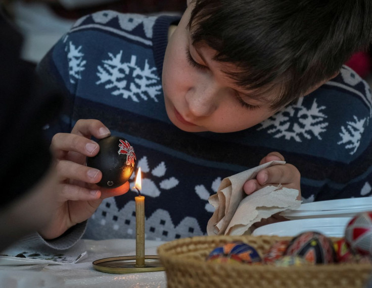 A boy paints an Easter egg in the traditional style, during a lesson for children of families fleeing from Russia's invasion of Ukraine, as part of the upcoming celebrations of Easter, in central Kyiv, Ukraine April 22, 2022. 
