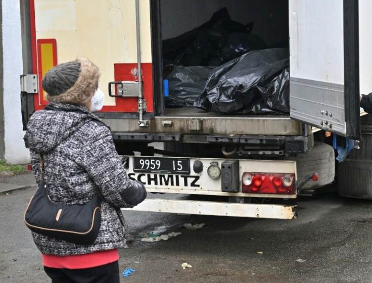 Tania Boikiv looks at a refrigerated lorry full of exhumed bodies in Bucha, seeking her husband's remains