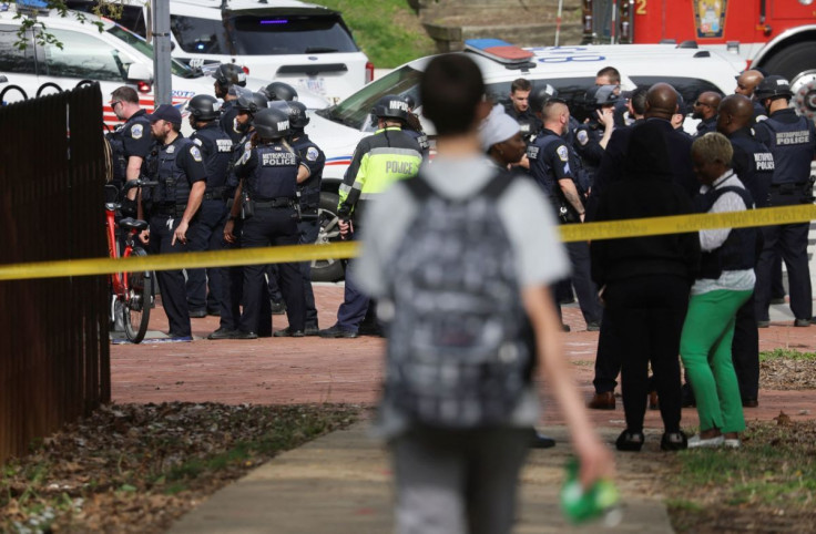 A student walks down the sidewalk towards a large crowd of Washington, D.C. Metropolitan Police and other law enforcement officers on the scene of a reported active shooter near Edmund Burke Middle School in the Cleveland Park neighborhood of Northwest Wa