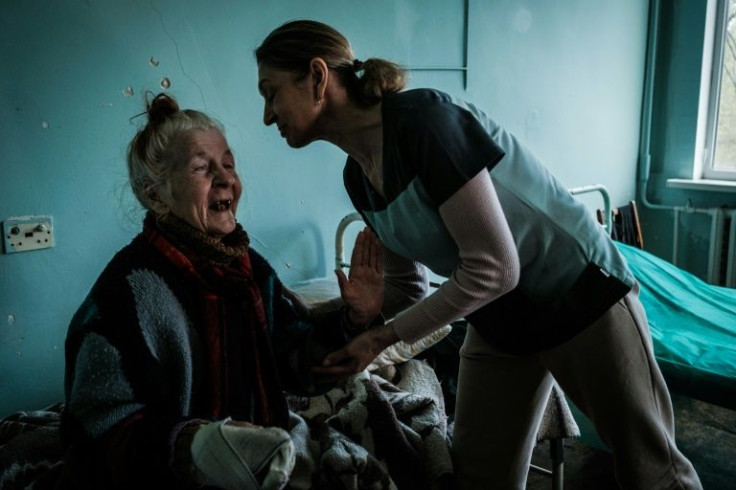 Eighty-one year old Yuliana Alekseena, left, says that her home was bombed and burned down, forcing her to flee