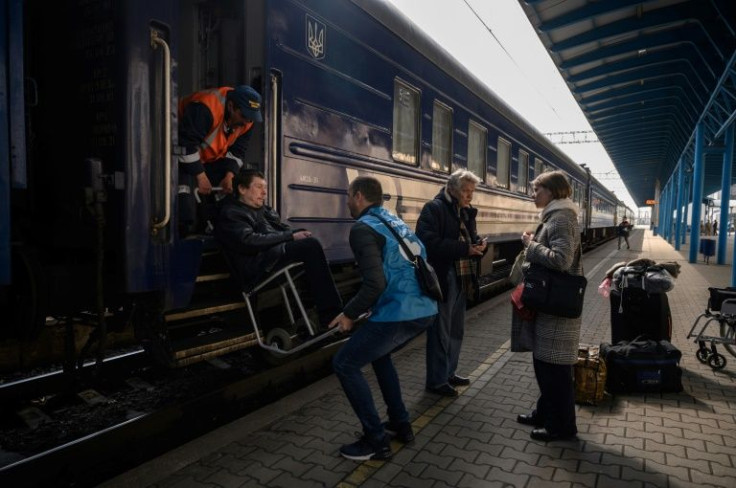 Internally displaced people board an evacuation train the day after arriving as part of a humanitarian convoy from the besieged city of Mariupol, at a railway station in the southern city of Zaporizhzhia on April 22, 2022