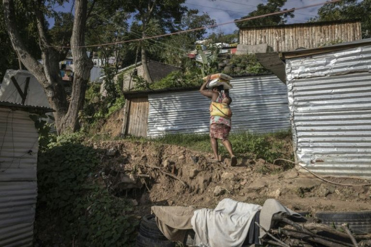 ENkanini resident Thulisile Ntobela carries donated food through the informal settlement where she put up a shack