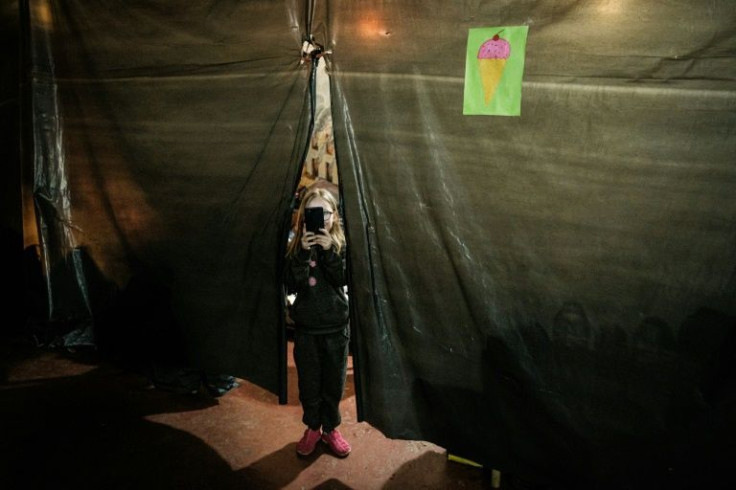 An internally displaced seven-year-old girl takes a picture in a bunker at a factory in Severodonetsk, eastern Ukraine, on April 22, 2022