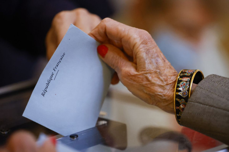 A woman casts her ballot in the second round of the 2022 French presidential election at a polling station in Lyon, France, April 24, 2022.