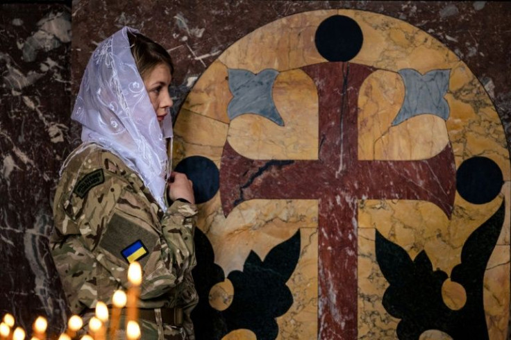 A female Ukrainian soldier crosses herself during an Orthodox Easter service in St. Volodymyr's Cathedral in Kyiv