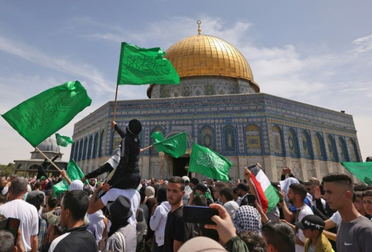 Palestinians wave their flag and Islamic flags inside Jerusalem's Al-Aqsa Mosque compound on Friday