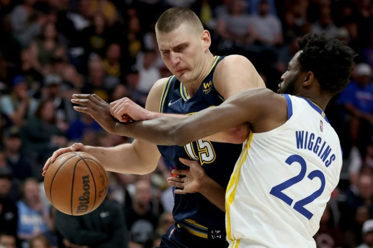 Denver's Nikola Jokic, driving to the hoop against Golden State's Andrew Wiggins, scored 37 points to lead the Nuggets over the Warriors in an NBA playoff game on Sunday