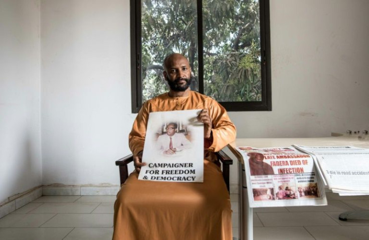 Baba Hydara holds a poster of his late father Deyda Hydara who was gunned down in 2004