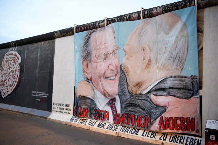 Former German Chancellor Gerhard Schroeder and Russian President Vladimir Putin are depicted in this graffiti exchanging a kiss at the East Side Gallery in Berlin, Germany April 2, 2022. Slogan reads in German and Russian "Dear God, help me to survive thi
