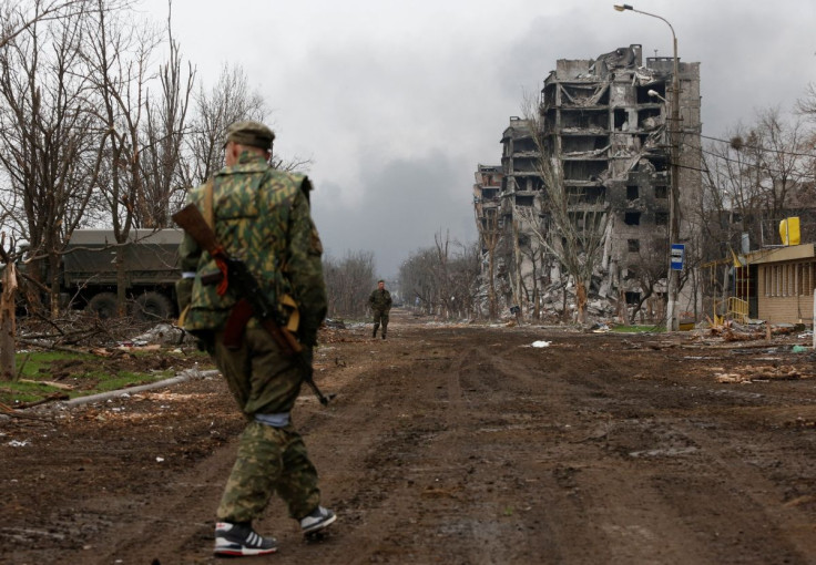 Service members of pro-Russian troops walk in the street during fighting in Ukraine-Russia conflict near a plant of Azovstal Iron and Steel Works company in the southern port city of Mariupol, Ukraine April 12, 2022. 