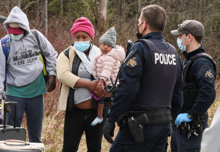 Asylum seekers cross into Canada from the U.S. border near a checkpoint on Roxham Road near Hemmingford, Quebec, Canada April 24, 2022. Picture taken April 24, 2022. 