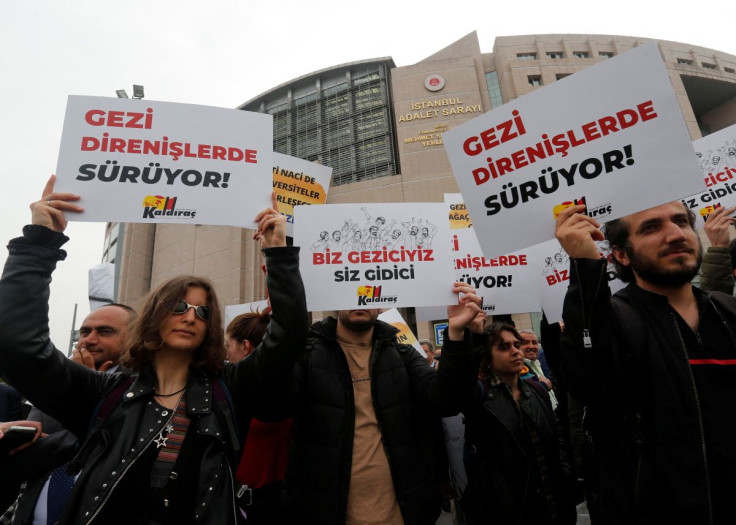 People gather in front of the Justice Palace, the Caglayan Courthouse, as a Turkish court holds a hearing of philanthropist Osman Kavala and 15 others over their role in nationwide protests in 2013, in Istanbul, Turkey April 22, 2022. The placards read: "