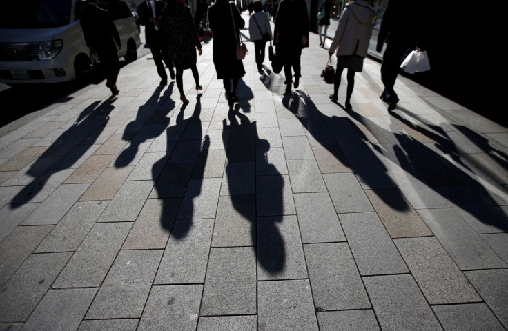 The shadows of pedestrians are pictured cast on a street in Tokyo, Japan, November 27, 2014.