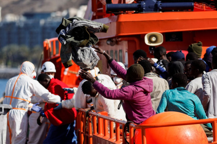 Rescuers help a migrant to disembark from a Spanish coast guard boat in the port of Arguineguin, in the island of Gran Canaria, Spain April 26, 2022. 