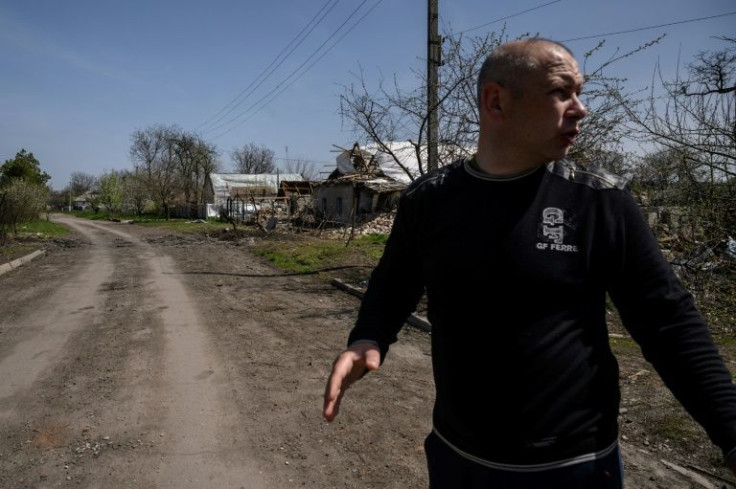 Town mayor Serguey Yarmak gestures to leave the area following the sound of nearby shelling
